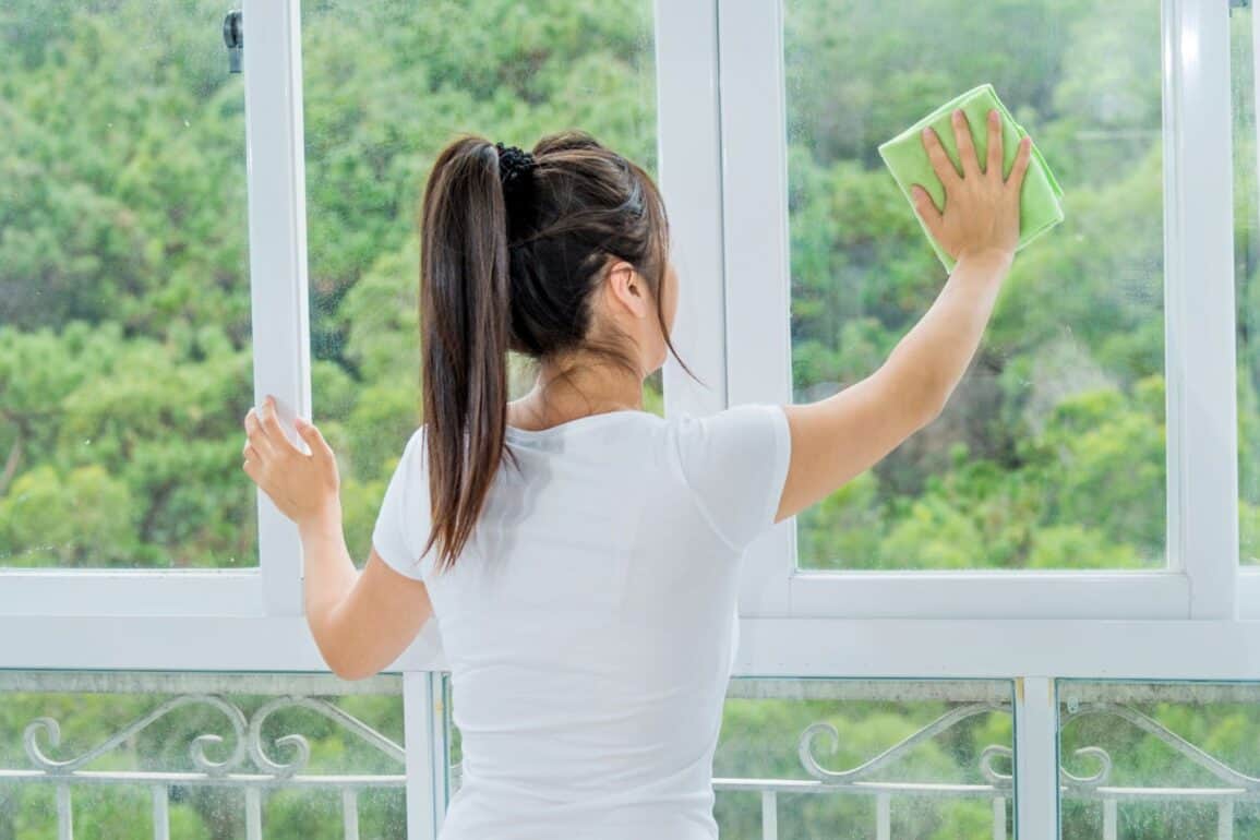 Femme qui nettoie vitre de maison
